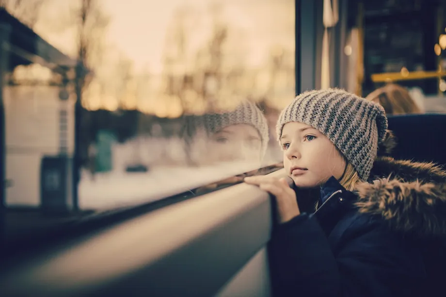 Illustrasjonsbilde - jente kikker ut av vinduet p&aring; en buss