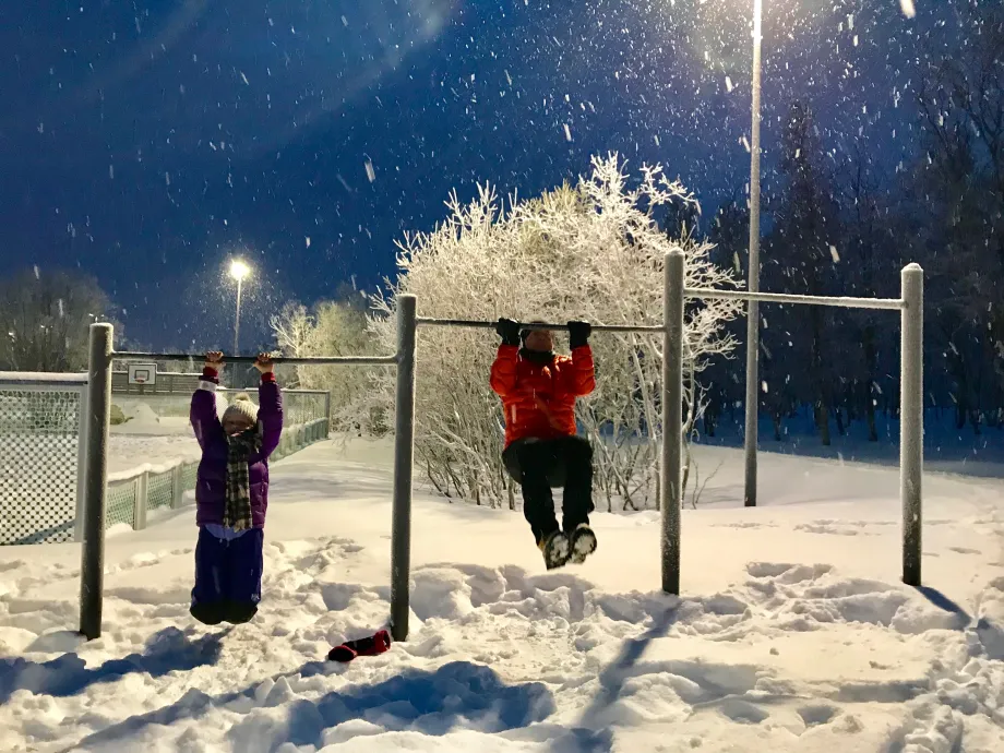Mann og jente henger i styrketreningsapperat p&aring; Charlottenlund aktivitets- og friluftspark