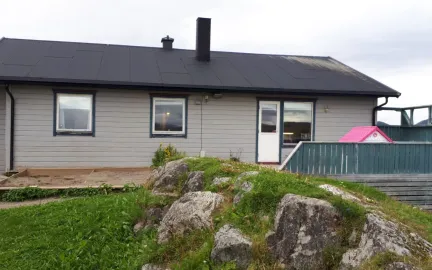 Trondjord barnehage sett utenfra med gr&oslash;nt gress en gr&aring; sommerdag 