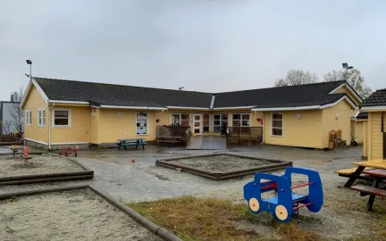 Uteomr&aring;de med sandkasse, benker og bord i Polarhagen barnehage