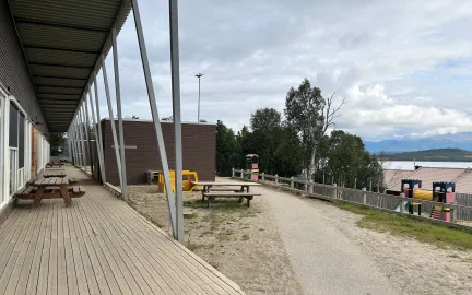 Uteomr&aring;de med benker og klatret&aring;rn en sen sommerdag med skyer og bl&aring; himmel.