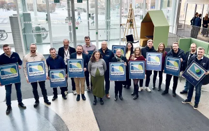Milj&oslash;sertifikatmottakere smiler til kamera i r&aring;dhusfoajeen.