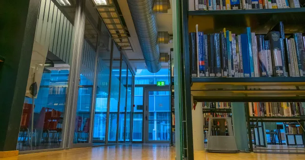 Shared reading på hovedbiblioteket En bokhylle sett nedenfra og opp står til høyre. Foto.