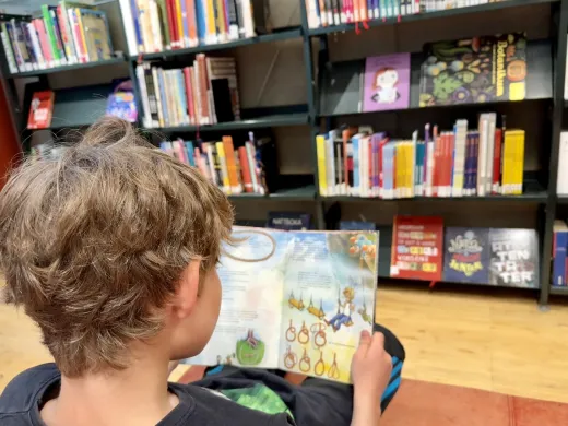 Barn leser bok p&aring; bibliotek